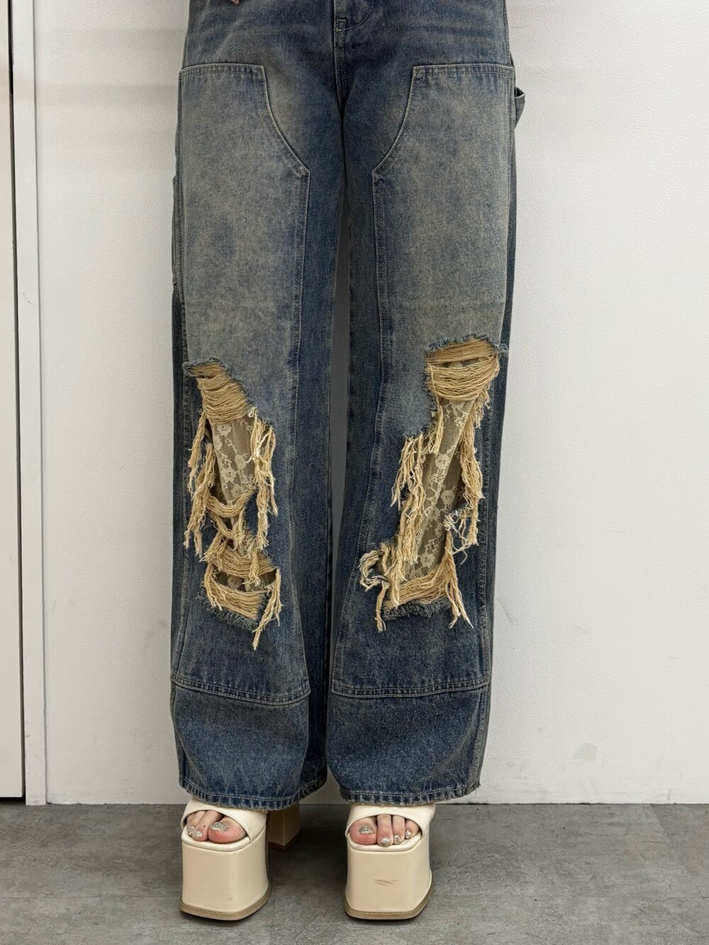 ホワイト系のサンダル、ブルー系のデニムパンツを着用したレディースの春コーディネートの4枚目の写真