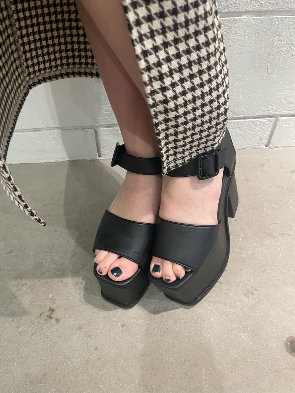 ブラック系のサンダル、ホワイト系のニット/セーター、その他のスカートを着用したレディースの春コーディネートの8枚目の写真