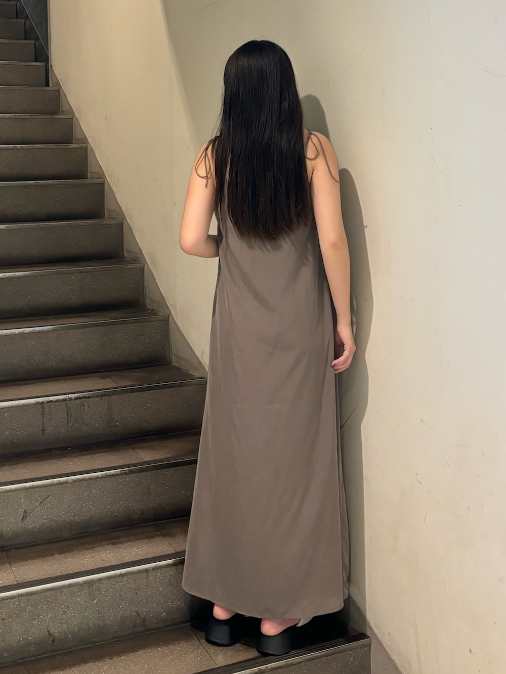 グレー系のワンピース、ホワイト系のサンダルを着用したレディースの春コーディネートの3枚目の写真