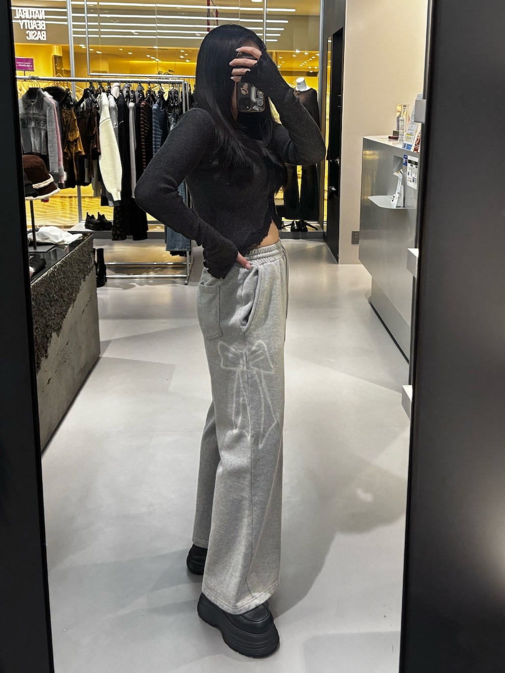 ブラック系のニット/セーター、グレー系のスウェットパンツ、ブラック系のローファーを着用したレディースの冬コーディネートの2枚目の写真