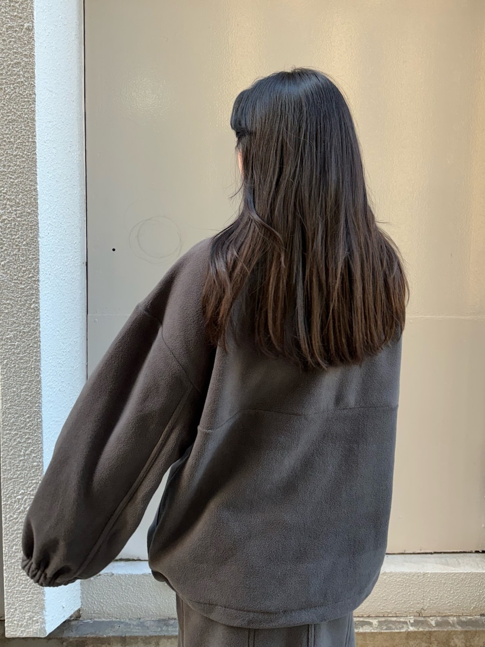 グレー系のTシャツ/カットソー、グレー系のスカート、ブラック系のブーツを着用したレディースの秋コーディネートの5枚目の写真