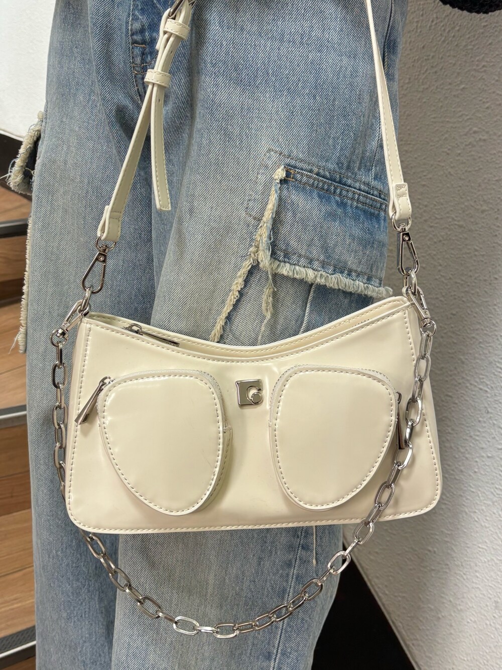 ブラック系のニット/セーター、ブルー系のデニムパンツを着用したレディースの春コーディネートの7枚目の写真