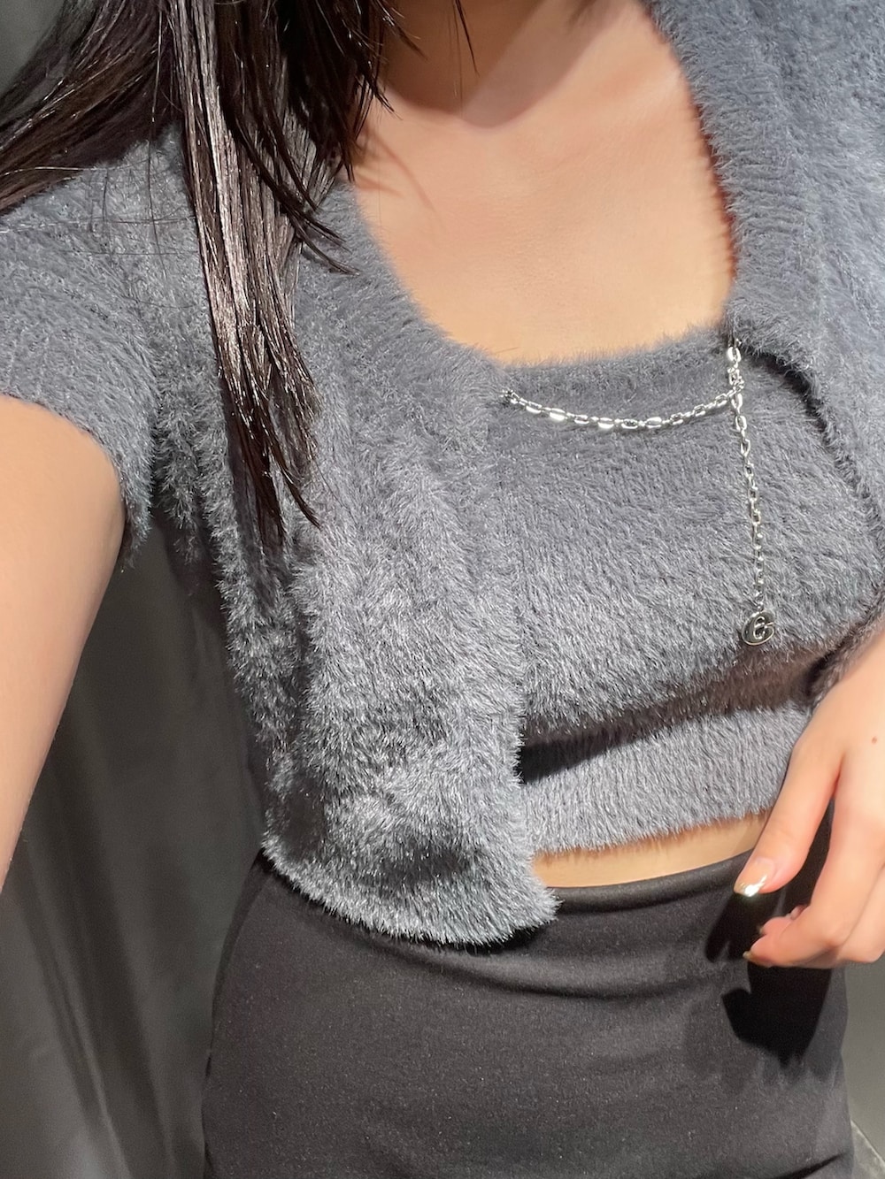 グレー系のニット/セーター、ブラック系のスカート、ブラック系のブーツを着用したレディースの夏コーディネートの3枚目の写真