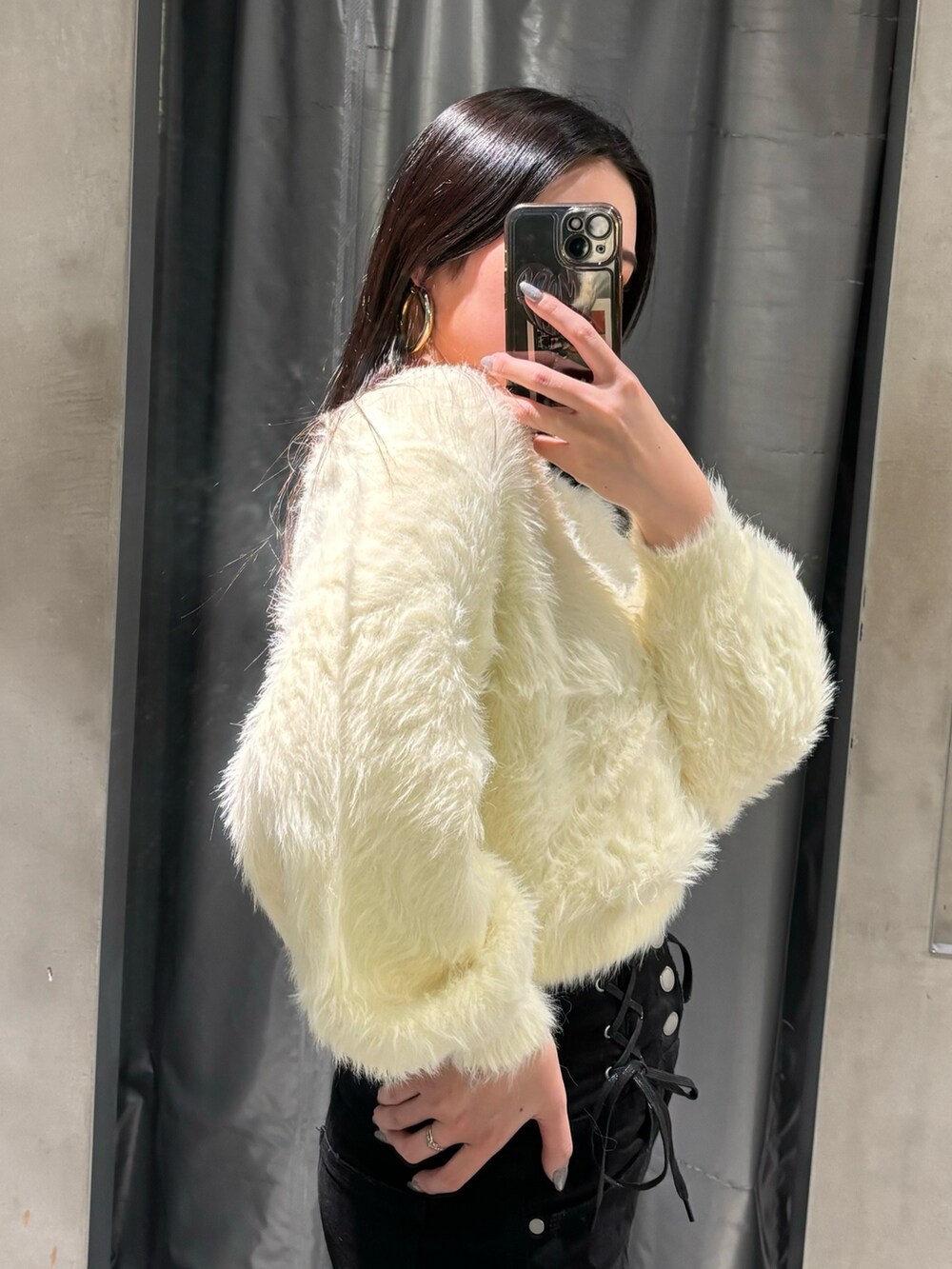 ブラック系のデニムパンツ、ホワイト系のニット/セーター、ブラック系のブーツを着用したレディースの冬コーディネートの4枚目の写真