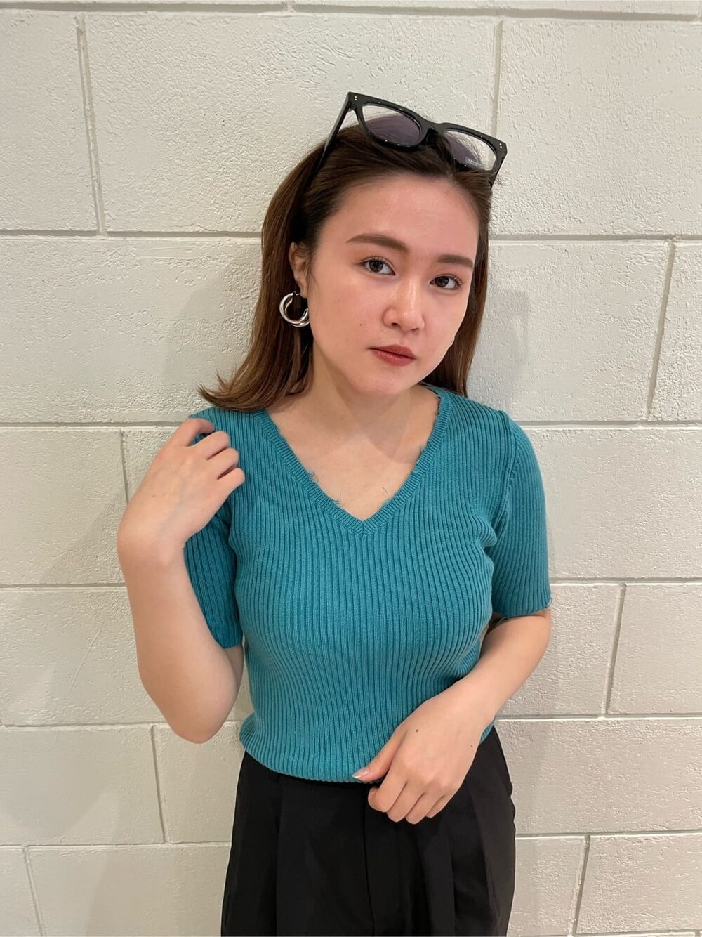 ブラック系のサンダル、ブラック系のスラックス、ブルー系のニット/セーターを着用したレディースの春コーディネートの3枚目の写真