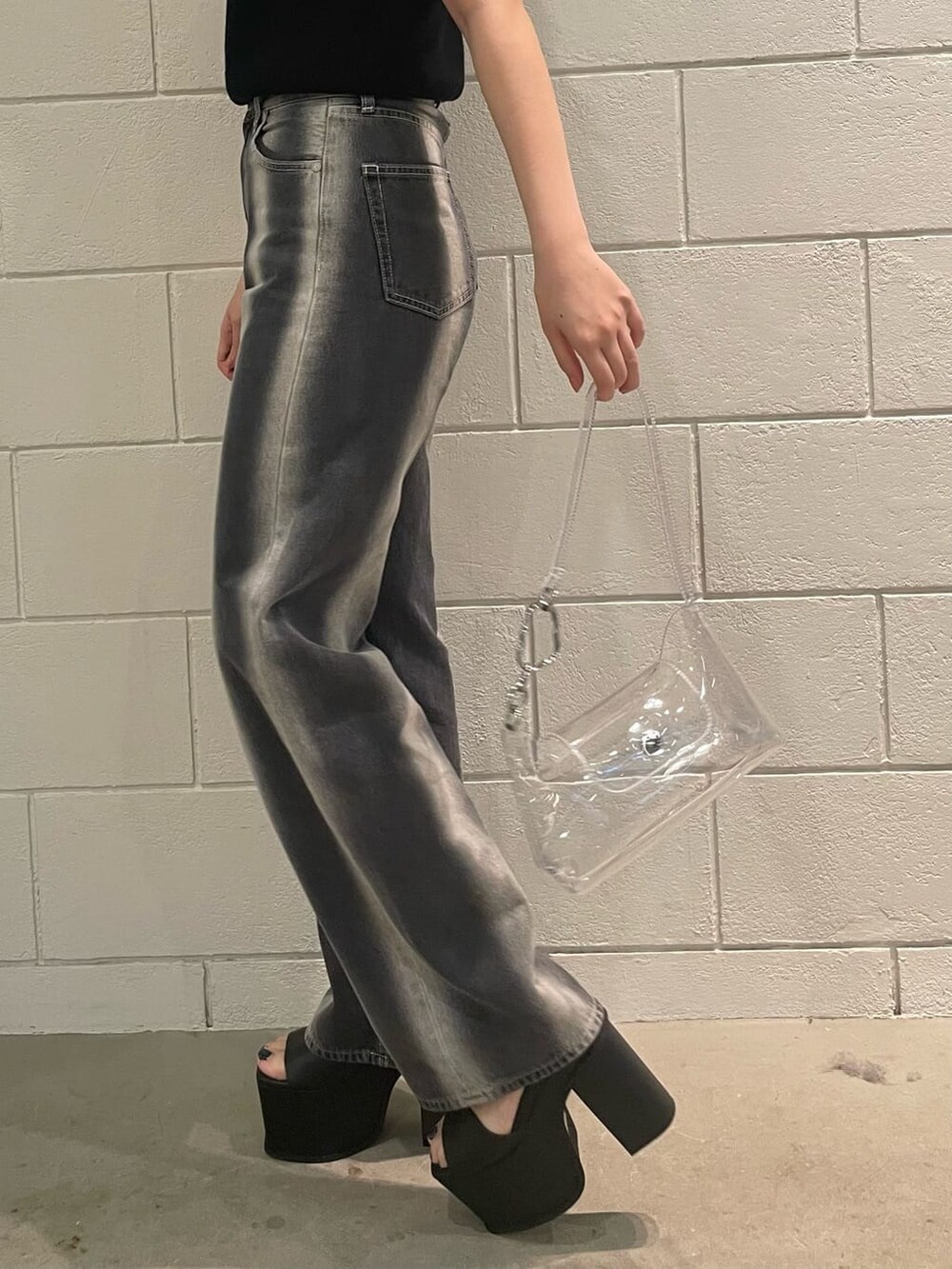 ブラック系のサンダル、ブラック系のタンクトップ、ブラック系のデニムパンツを着用したレディースの春コーディネートの7枚目の写真