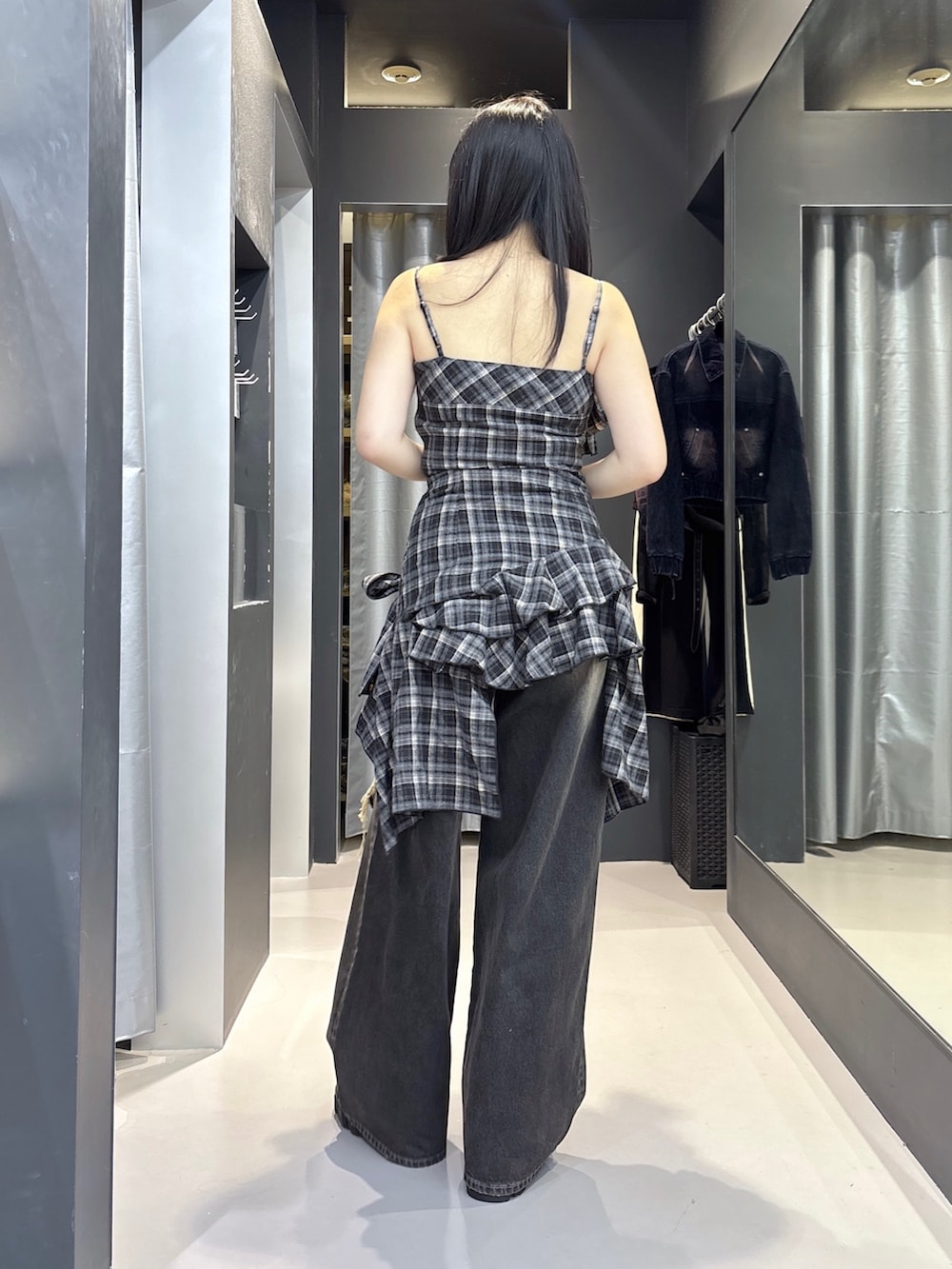 ブラック系のブーツ、ブラック系のデニムパンツ、ブラック系のワンピースを着用したレディースの夏コーディネートの3枚目の写真