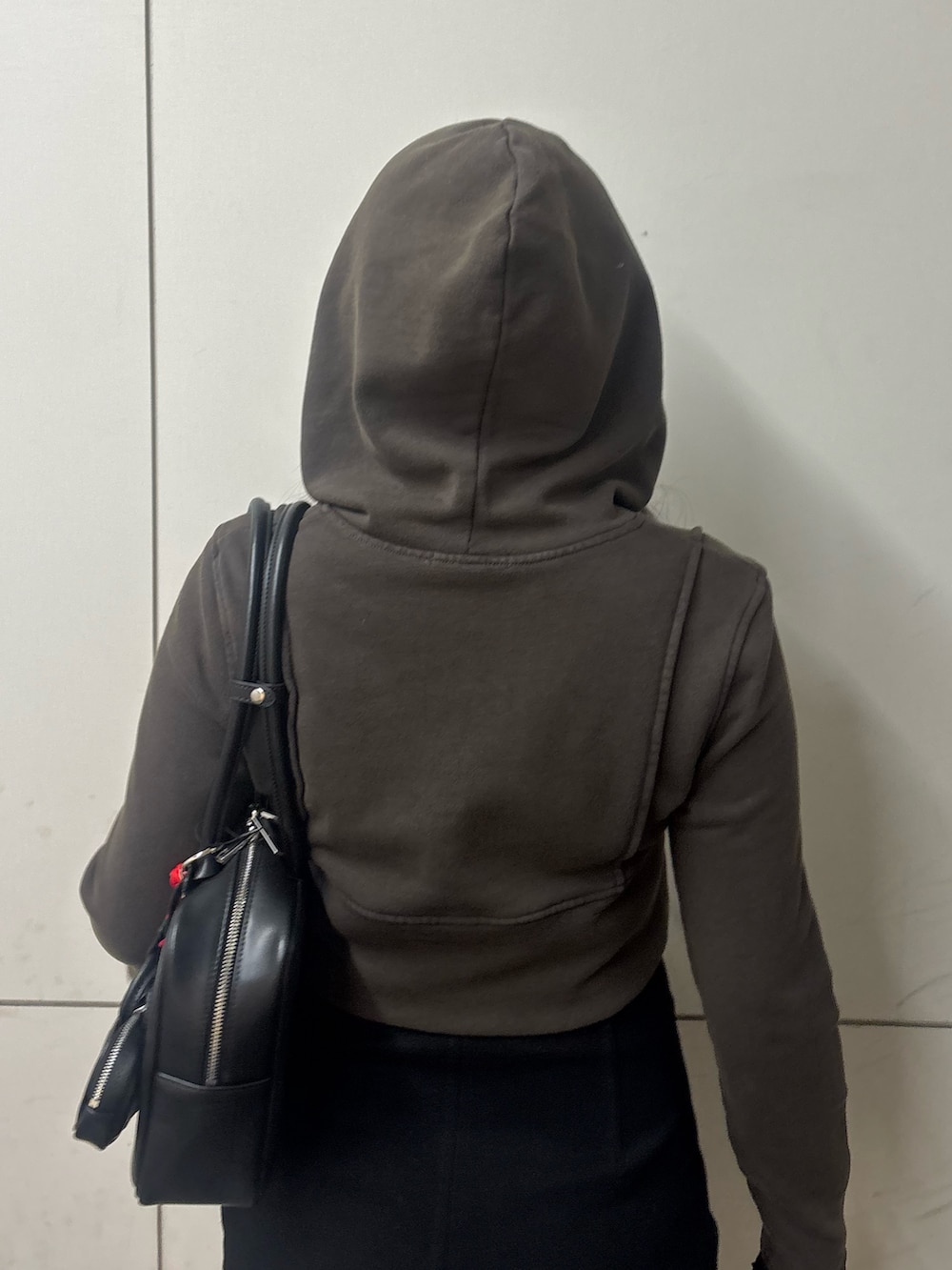 ブラック系のスカート、ブラック系のブーツ、ブラック系のハンドバッグを着用したレディースの春コーディネートの6枚目の写真