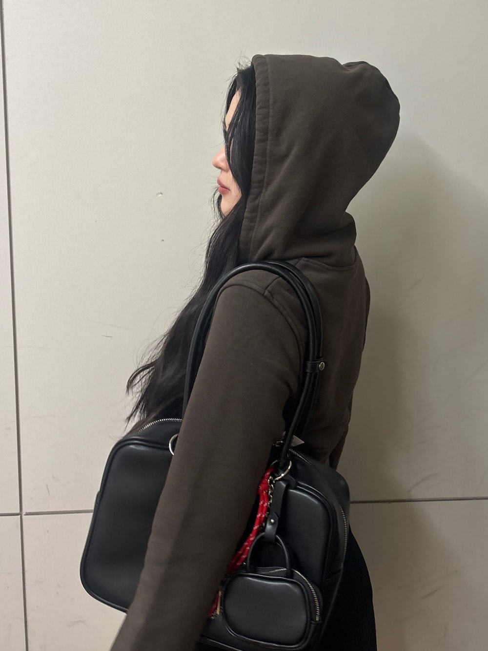 ブラック系のスカート、ブラック系のブーツ、ブラック系のハンドバッグを着用したレディースの春コーディネートの5枚目の写真