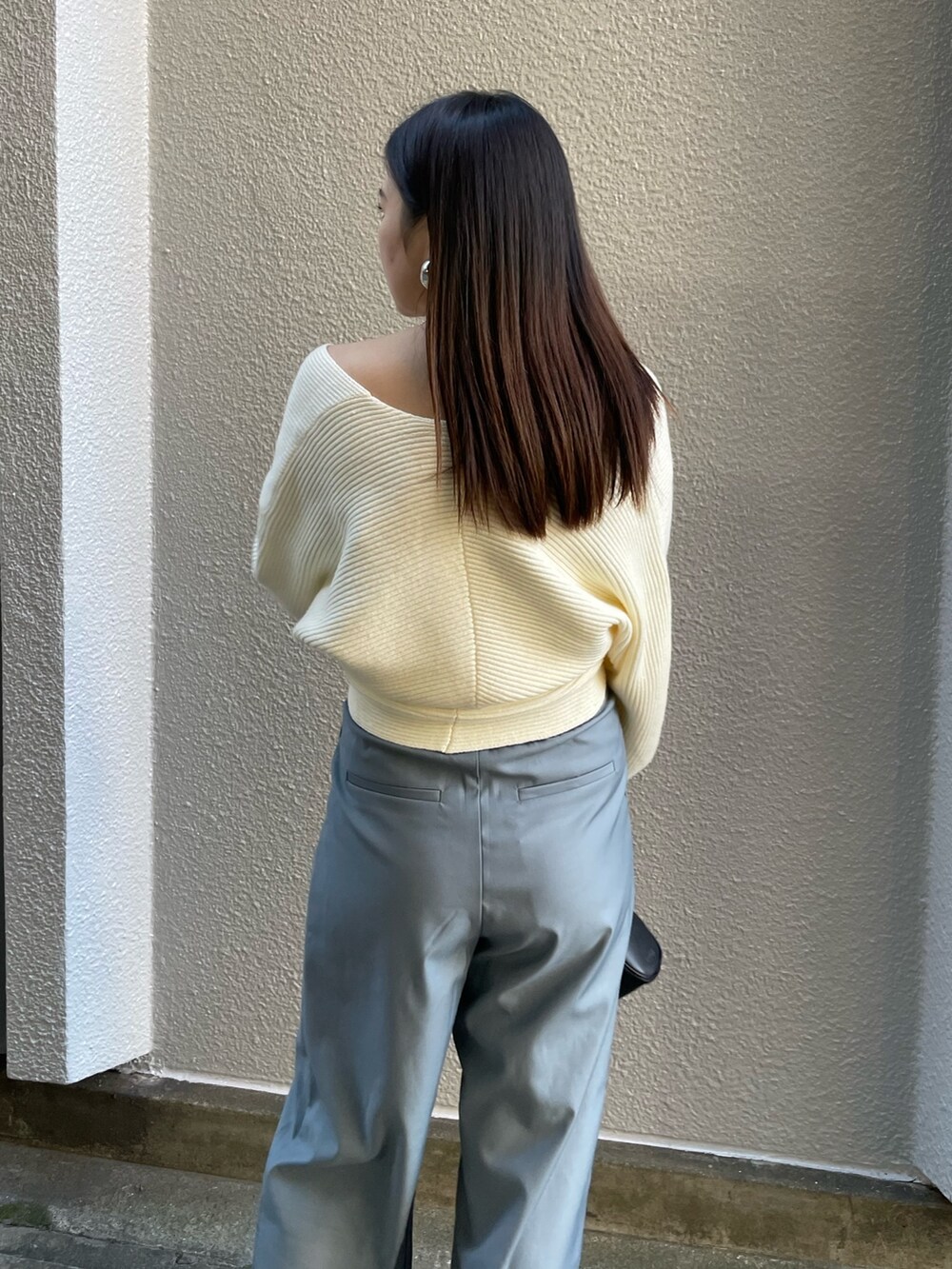 ホワイト系のニット/セーター、ブルー系のその他パンツ、ブラック系のブーツを着用したレディースの冬コーディネートの6枚目の写真