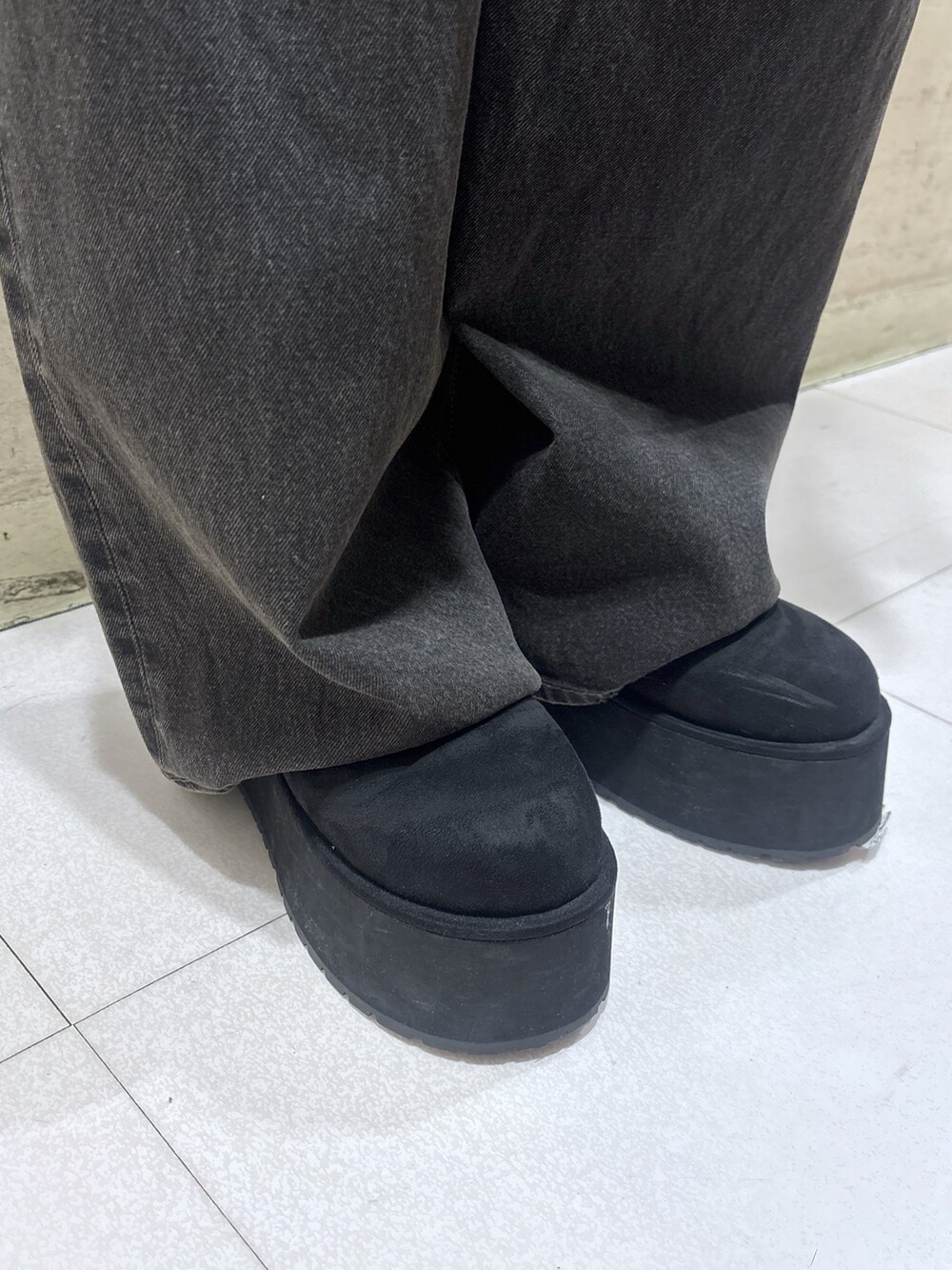 ブラック系のスリッポン、ブラック系のデニムパンツ、ブラック系のショルダーバッグを着用したレディースの秋コーディネートの5枚目の写真