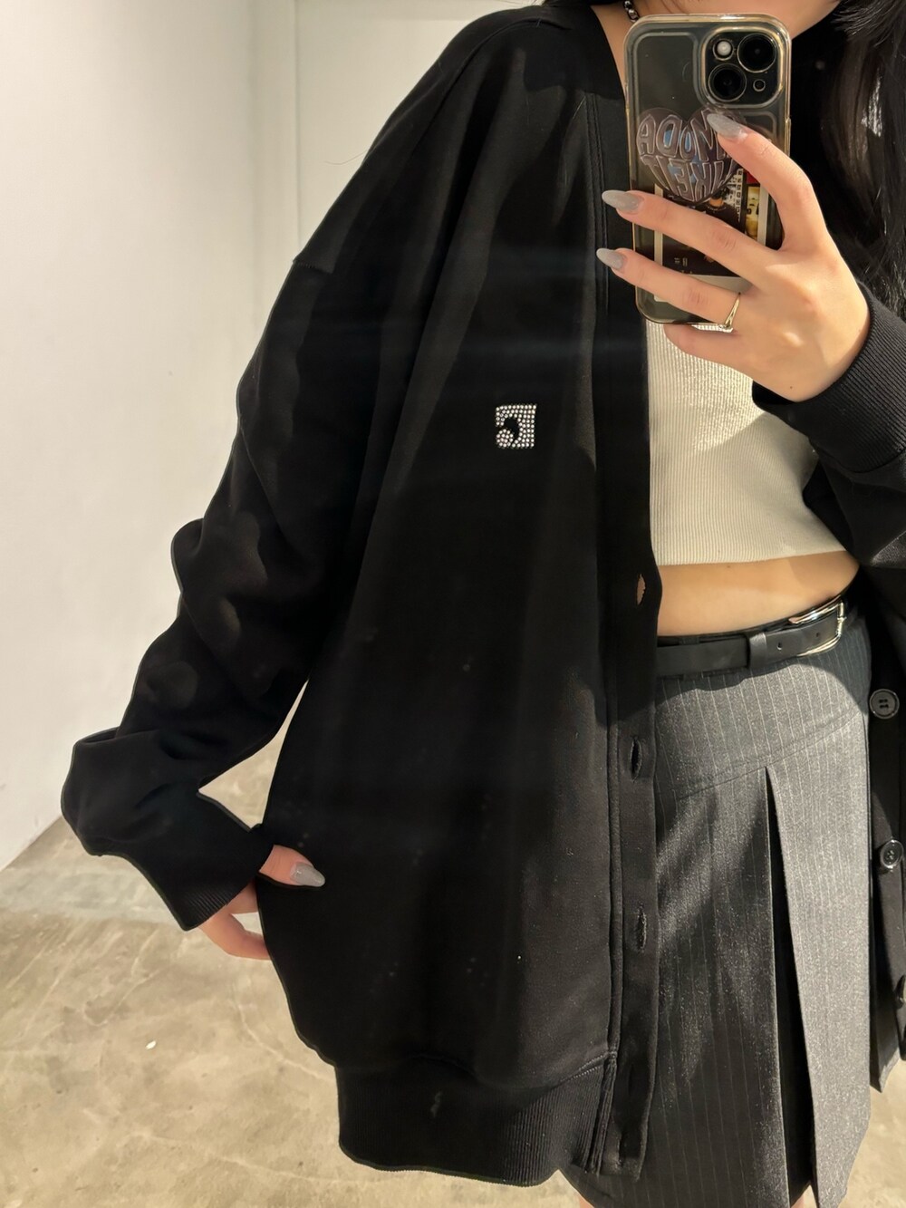 ブラック系のスカート、ブラック系のカーディガン/ボレロ、ブラック系のキャミソールを着用したレディースの春コーディネートの3枚目の写真