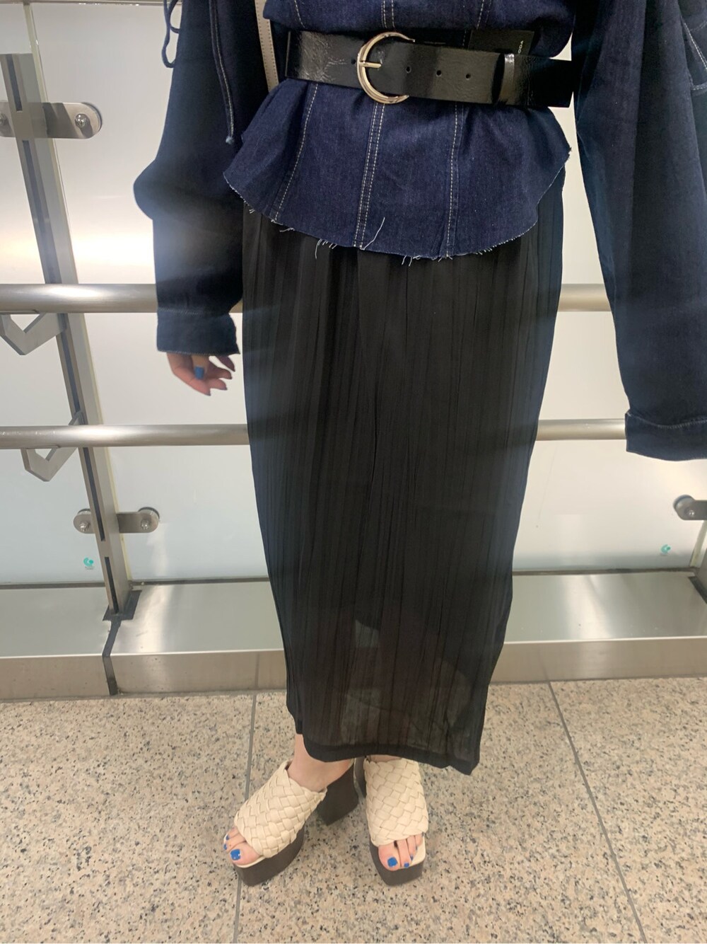 ブラック系のスカート、ホワイト系のショルダーバッグ、ホワイト系のサンダルを着用したレディースの春コーディネートの5枚目の写真