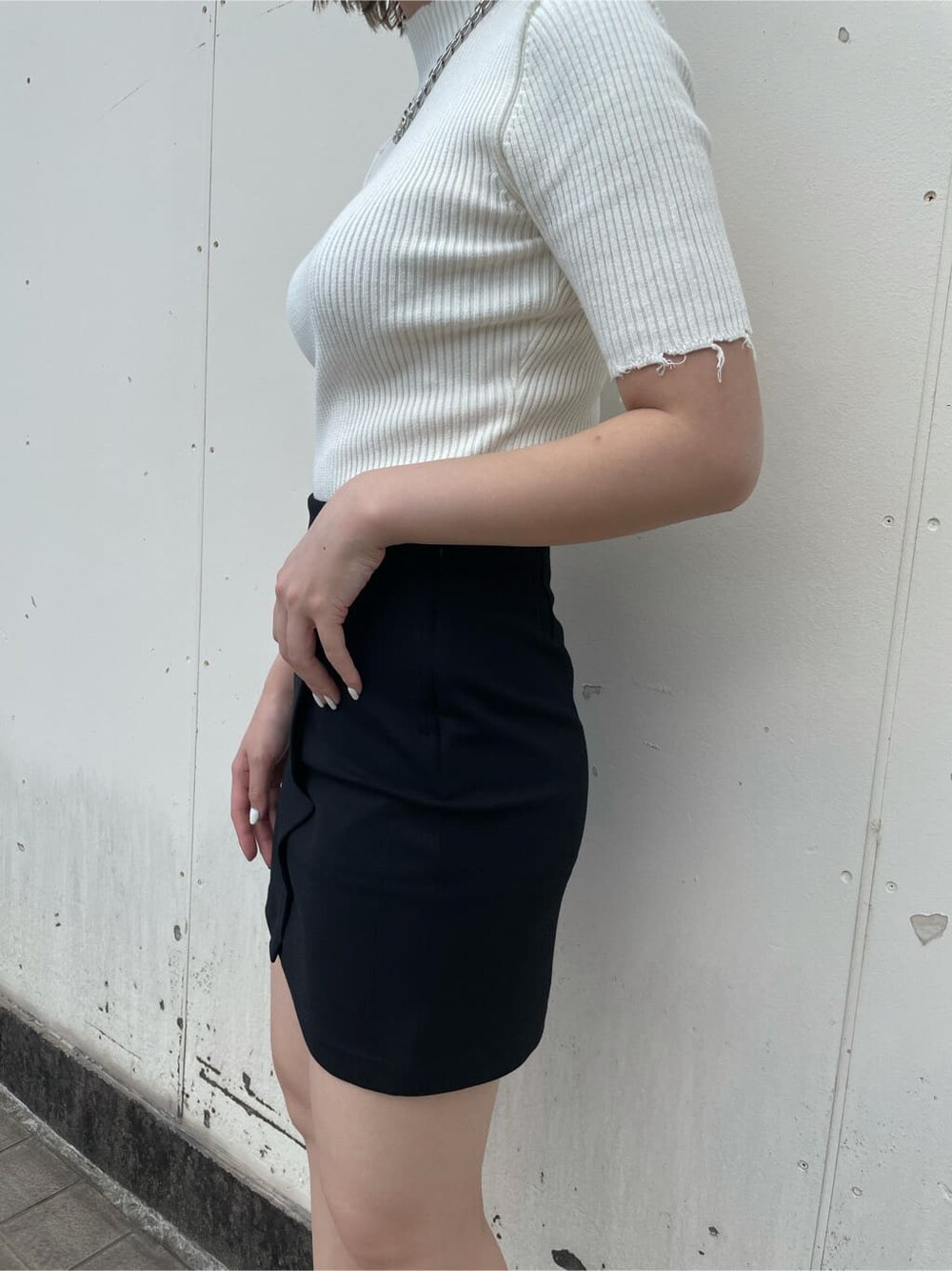 ブラック系のスカート、ブラック系のサンダル、ホワイト系のニット/セーターを着用したレディースの秋コーディネートの8枚目の写真