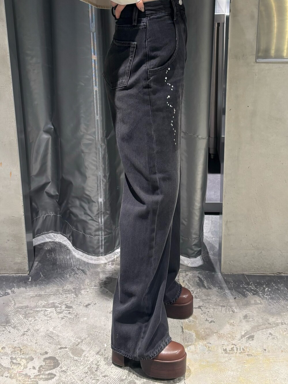 ブラック系のデニムパンツ、ブラック系のブーツ、ホワイト系のシャツ/ブラウスを着用したレディースの秋コーディネートの6枚目の写真