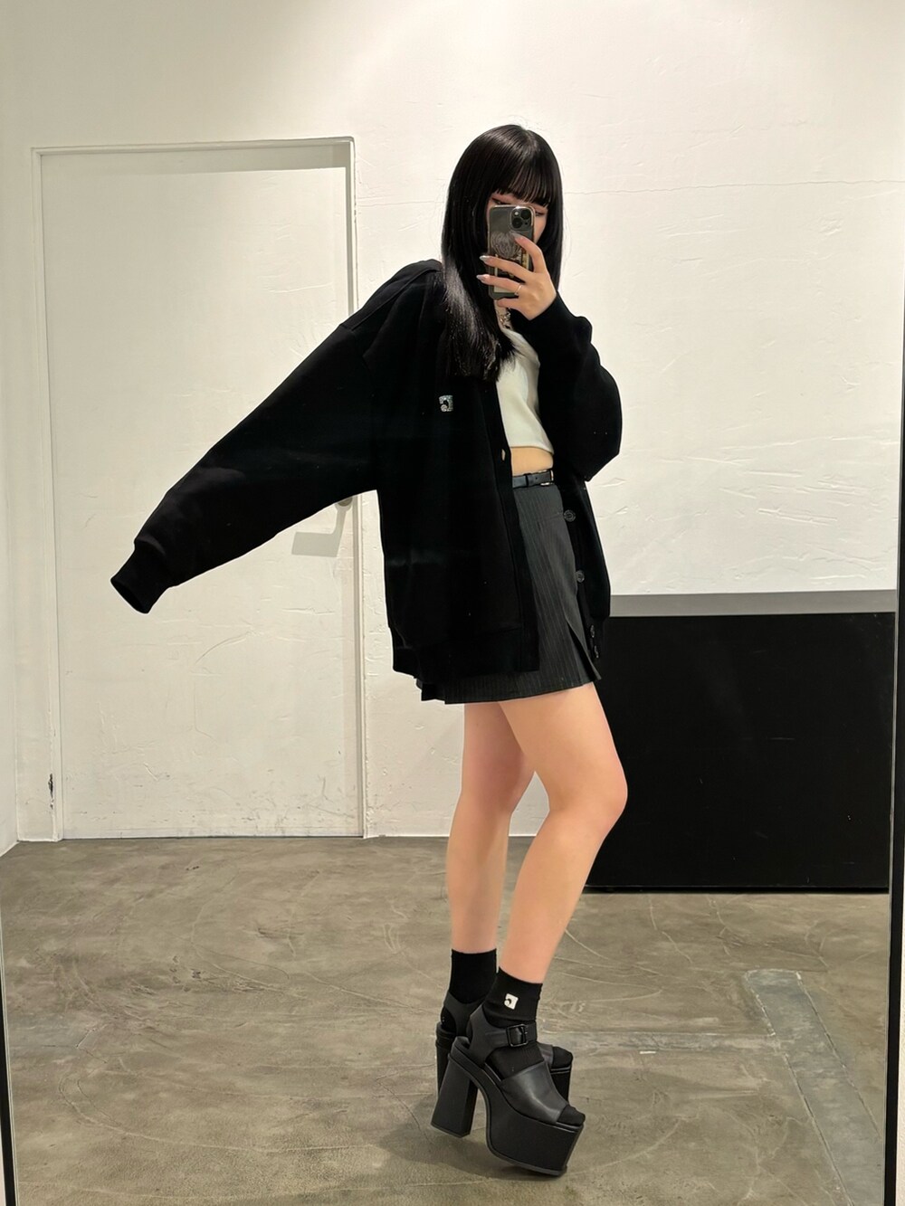 ブラック系のスカート、ブラック系のカーディガン/ボレロ、ブラック系のキャミソールを着用したレディースの春コーディネートの2枚目の写真