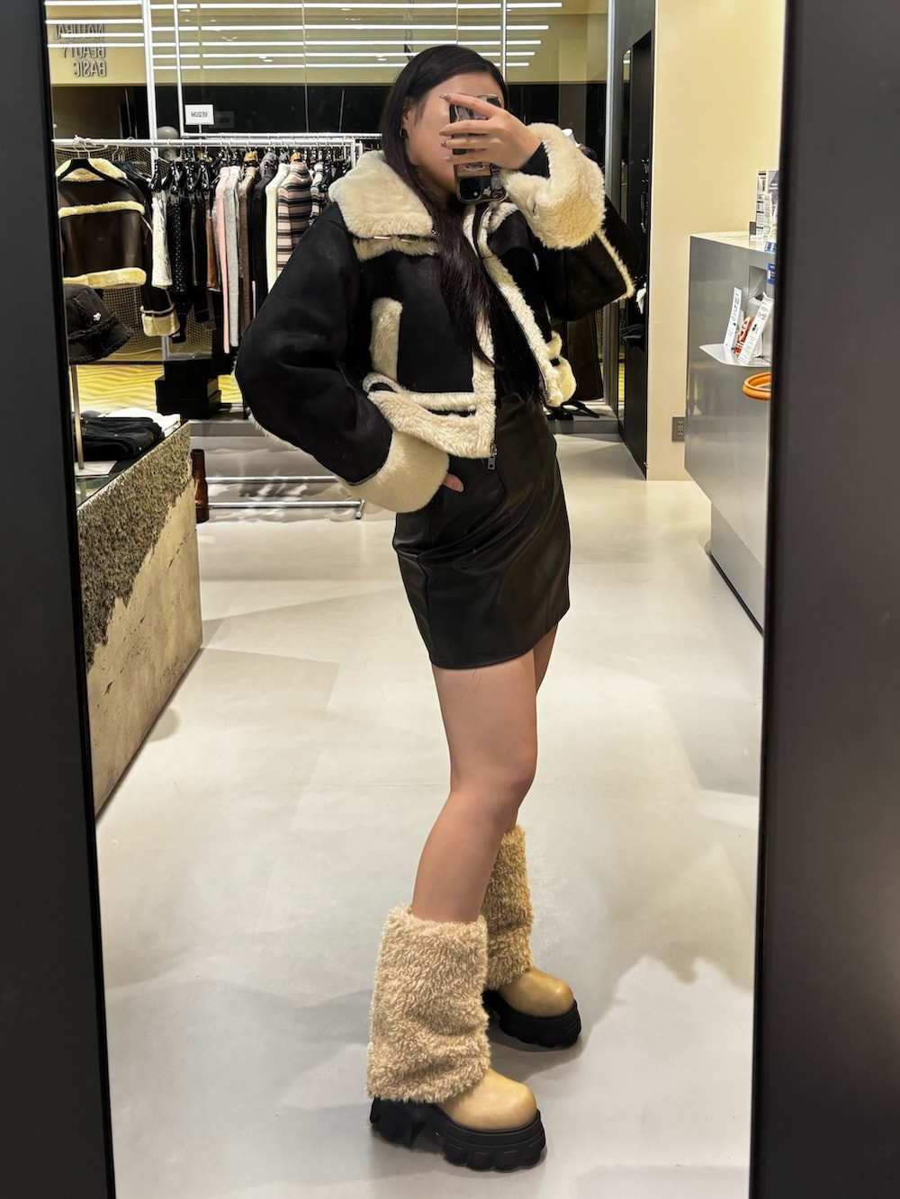 ブラック系のブルゾン、ブラック系のニット/セーター、ホワイト系のブーツを着用したレディースの冬コーディネートの2枚目の写真