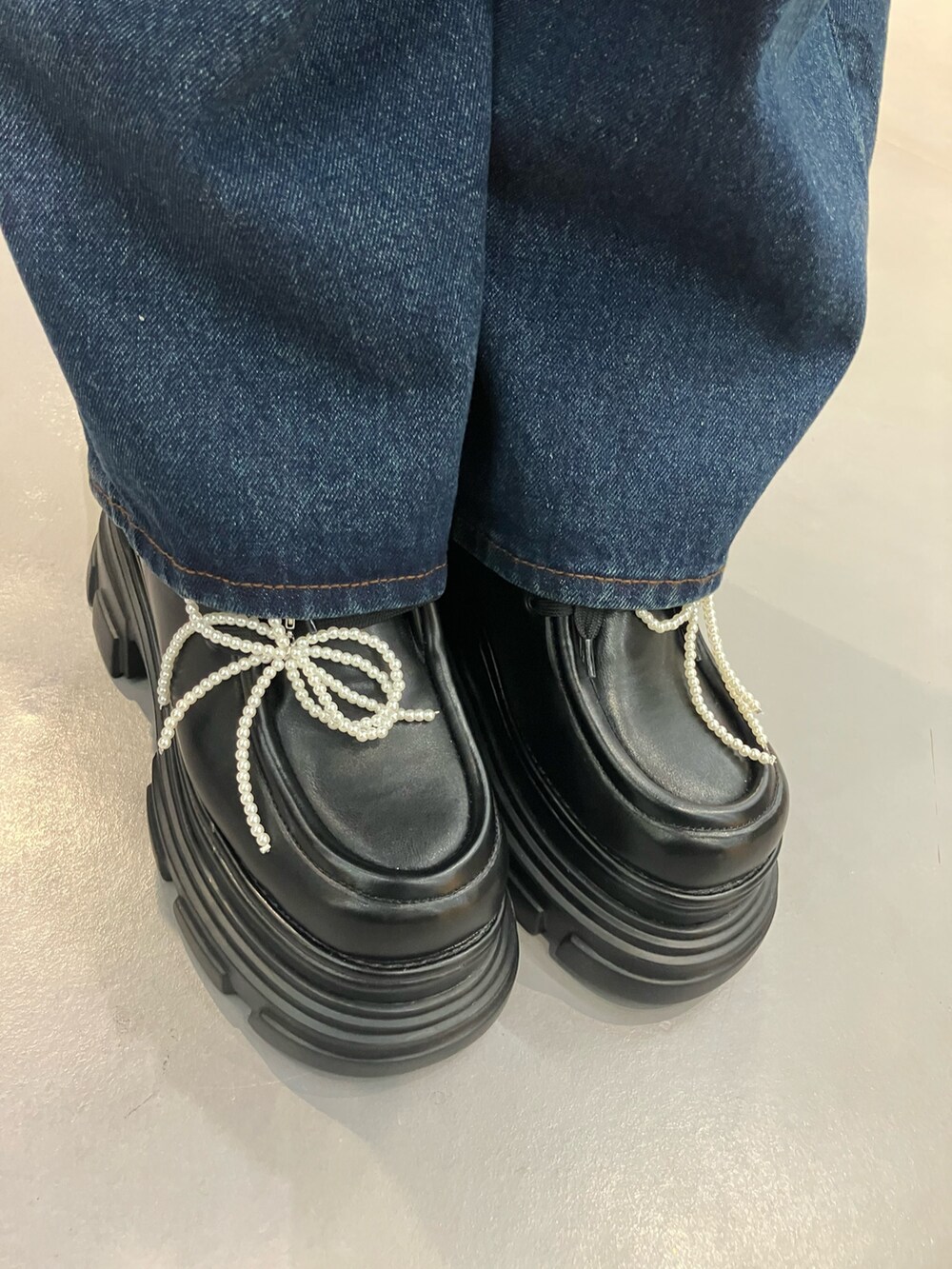 グレー系のTシャツ/カットソー、ブルー系のデニムパンツ、ブラック系のローファーを着用したレディースの秋コーディネートの5枚目の写真