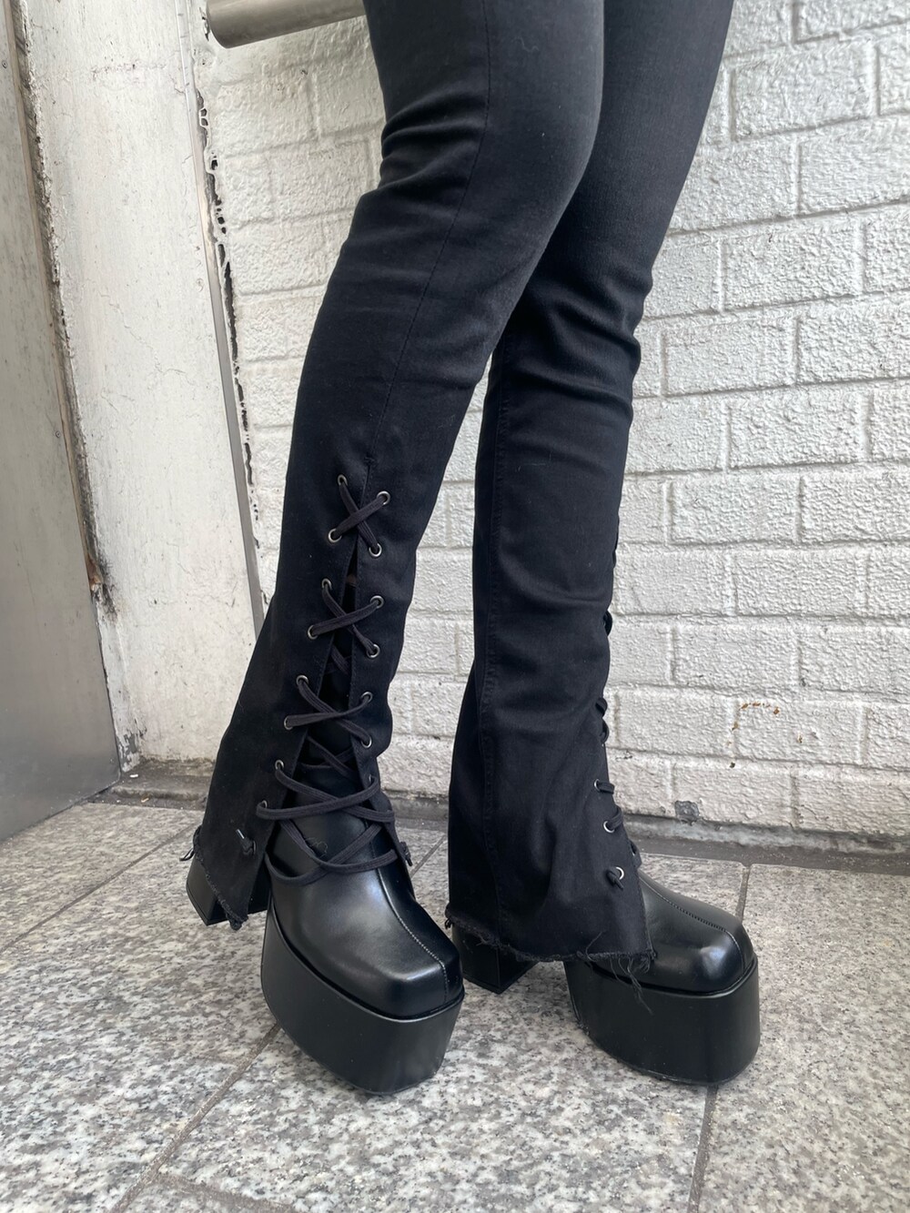 パープル系のチェスターコート、パープル系のニット/セーター、ブラック系のデニムパンツを着用したレディースの冬コーディネートの6枚目の写真