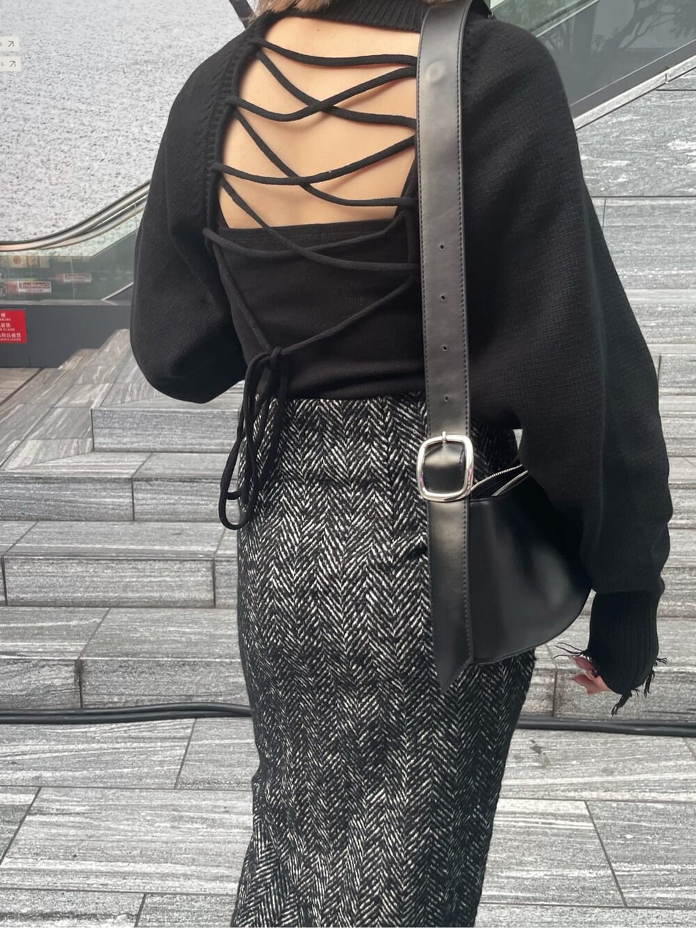 ブラック系のスカート、ブラック系のニット/セーター、ブラック系のキャミソールを着用したレディースの秋コーディネートの5枚目の写真