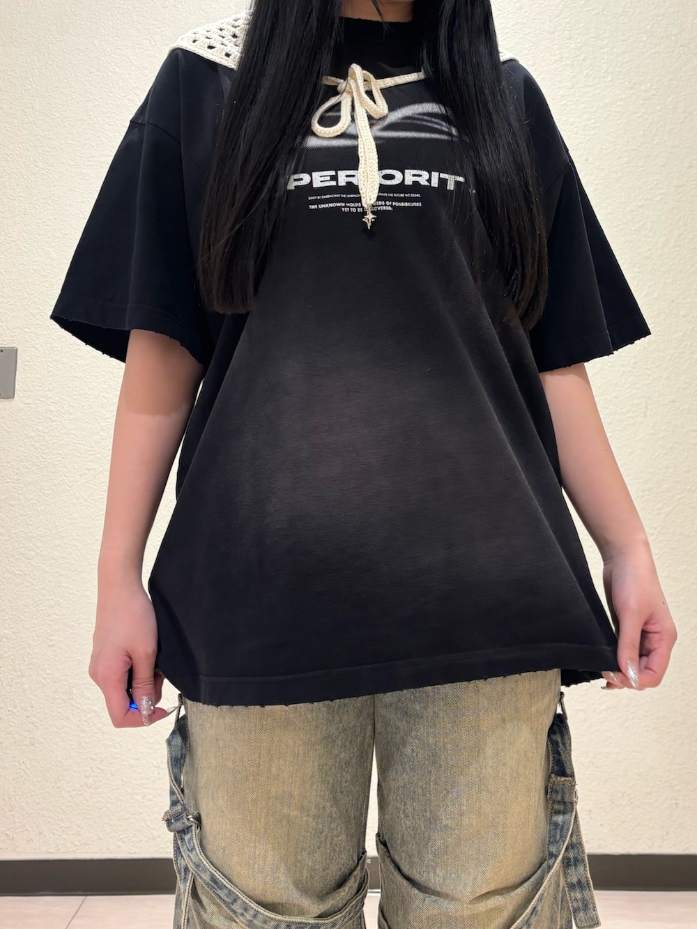ブラック系のスニーカー、ベージュ系のデニムパンツ、ブラック系のTシャツ/カットソーを着用したレディースの春コーディネートの4枚目の写真
