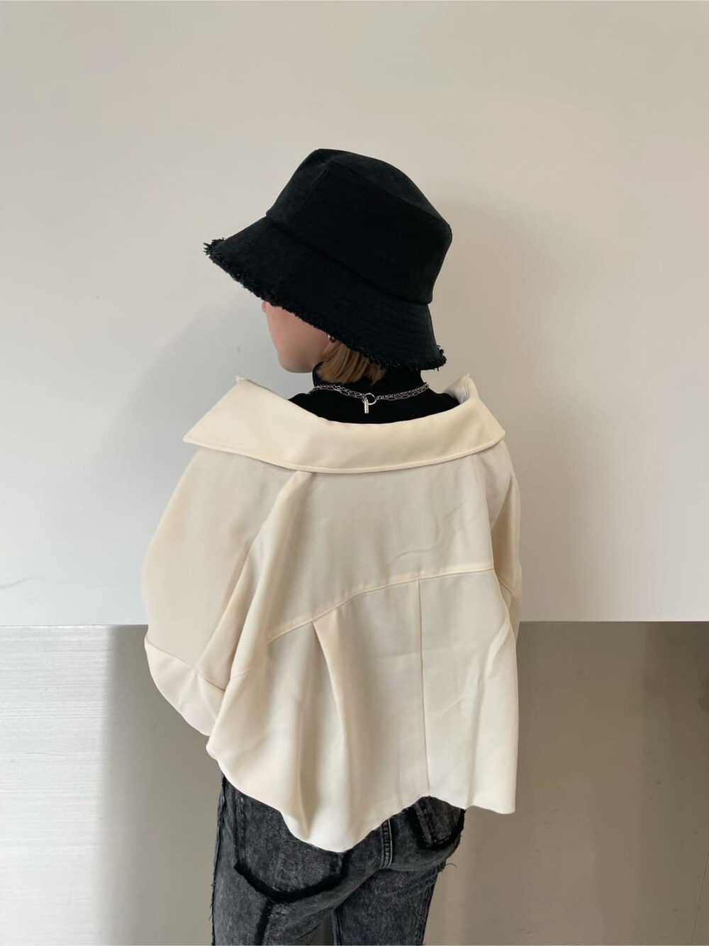 ブラック系のデニムパンツ、ホワイト系のテーラードジャケット、ブラック系のTシャツ/カットソーを着用したレディースの秋コーディネートの4枚目の写真