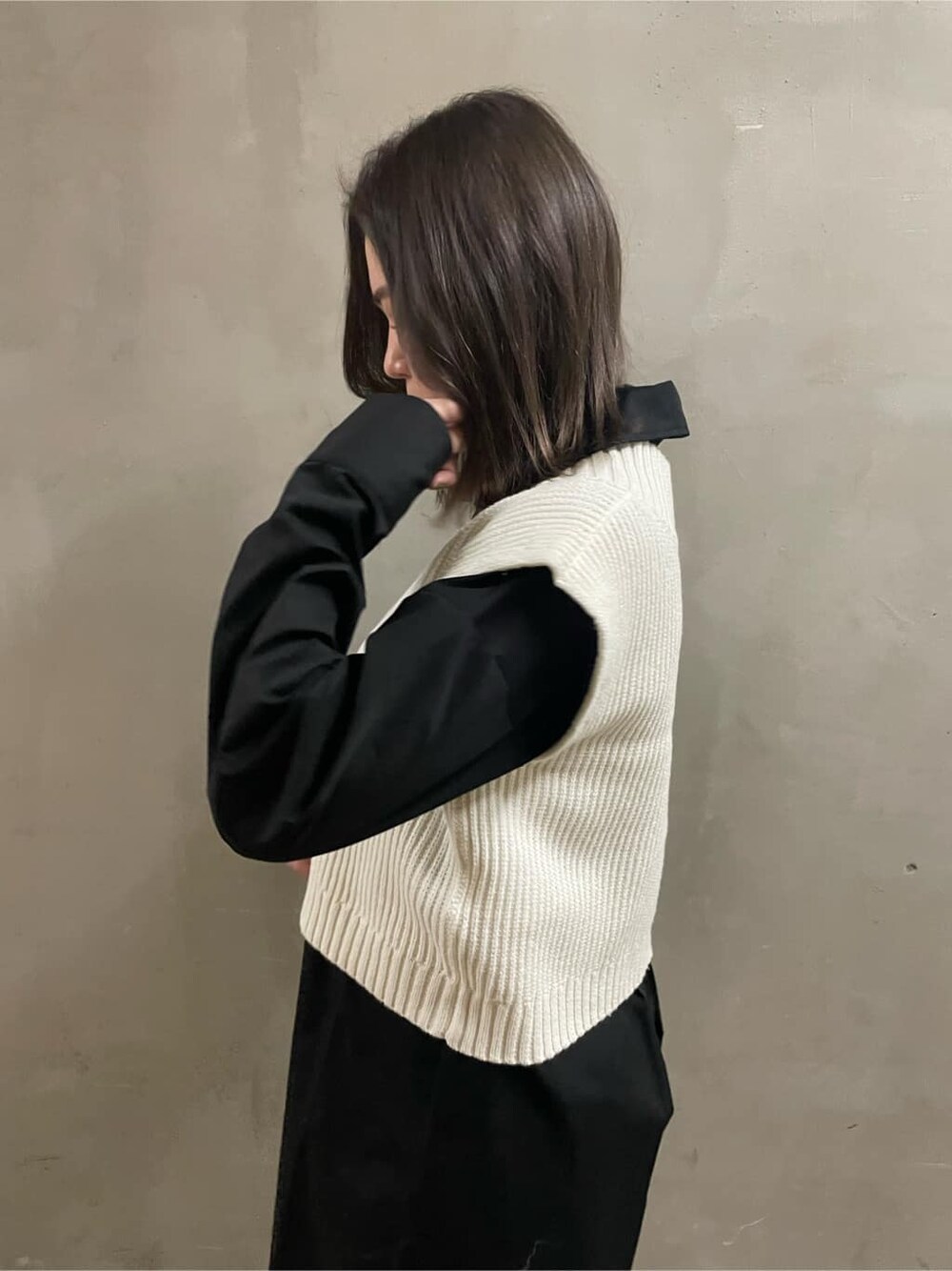 ホワイト系のブーツ、ブラック系のシャツ/ブラウス、ホワイト系のベストを着用したレディースの春コーディネートの5枚目の写真