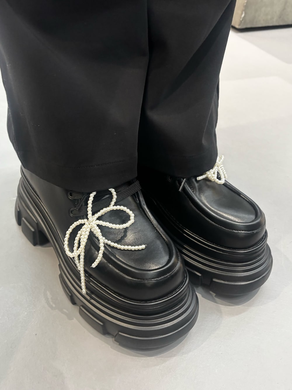 ブラック系のローファー、ホワイト系のニット/セーター、ブラック系のその他パンツを着用したレディースの秋コーディネートの5枚目の写真