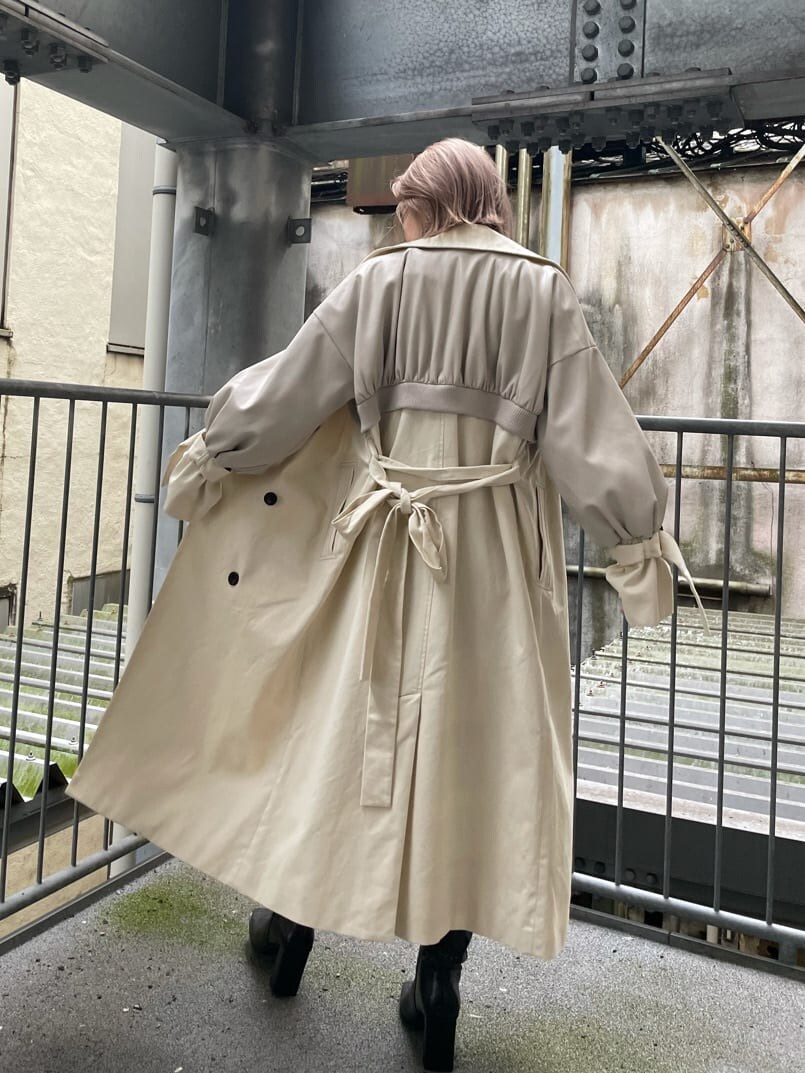 ブラック系のデニムパンツ、ホワイト系のトレンチコート、その他のブーツを着用したレディースの秋コーディネートの2枚目の写真