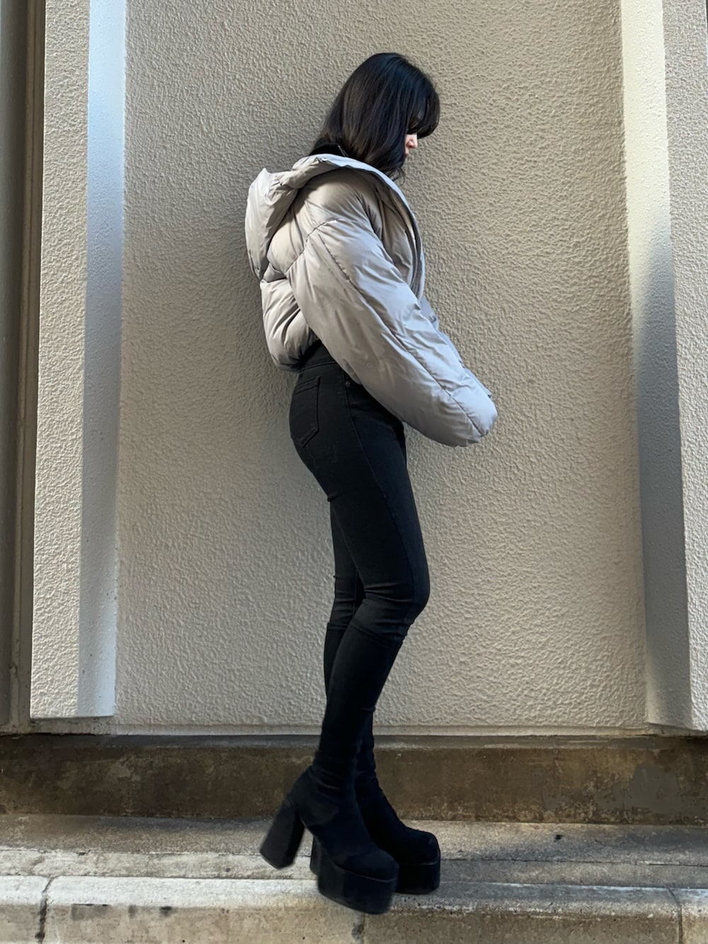 ブルー系のニット/セーター、グレー系のダウンジャケット/コート、ブラック系のデニムパンツを着用したレディースの冬コーディネートの2枚目の写真