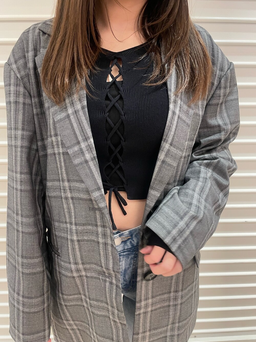 ブラック系のテーラードジャケット、ブルー系のニット/セーター、ブルー系のデニムパンツを着用したレディースの春コーディネートの7枚目の写真