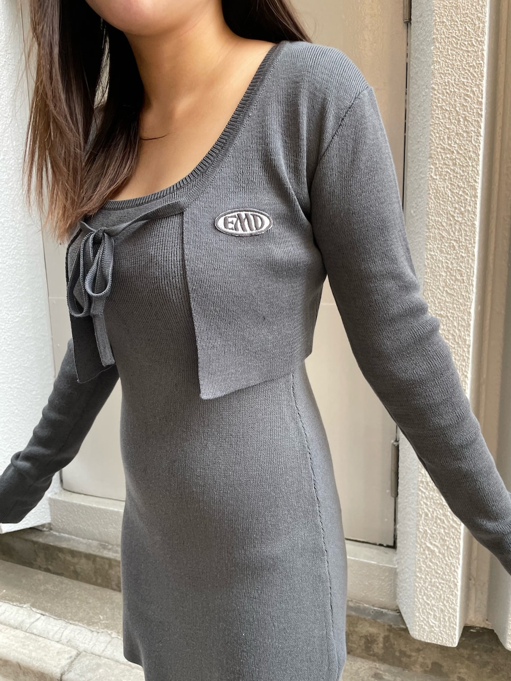 グレー系のワンピース、ブラック系のブーツを着用したレディースの春コーディネートの6枚目の写真