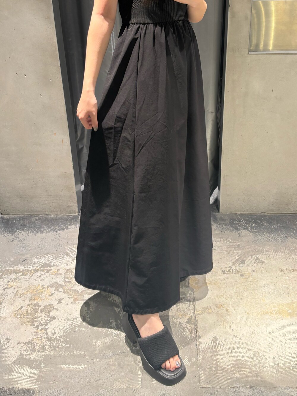 ブラック系のワンピース、ブラック系のサンダルを着用したレディースの夏コーディネートの5枚目の写真