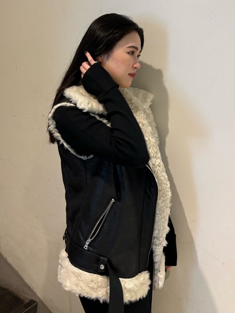 ブラック系のムートンコート、ブラック系のワンピース、ホワイト系のブーツを着用したレディースの秋コーディネートの5枚目の写真