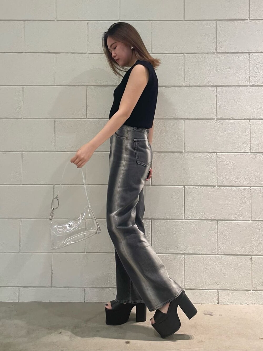 ブラック系のサンダル、ブラック系のタンクトップ、ブラック系のデニムパンツを着用したレディースの春コーディネートの2枚目の写真