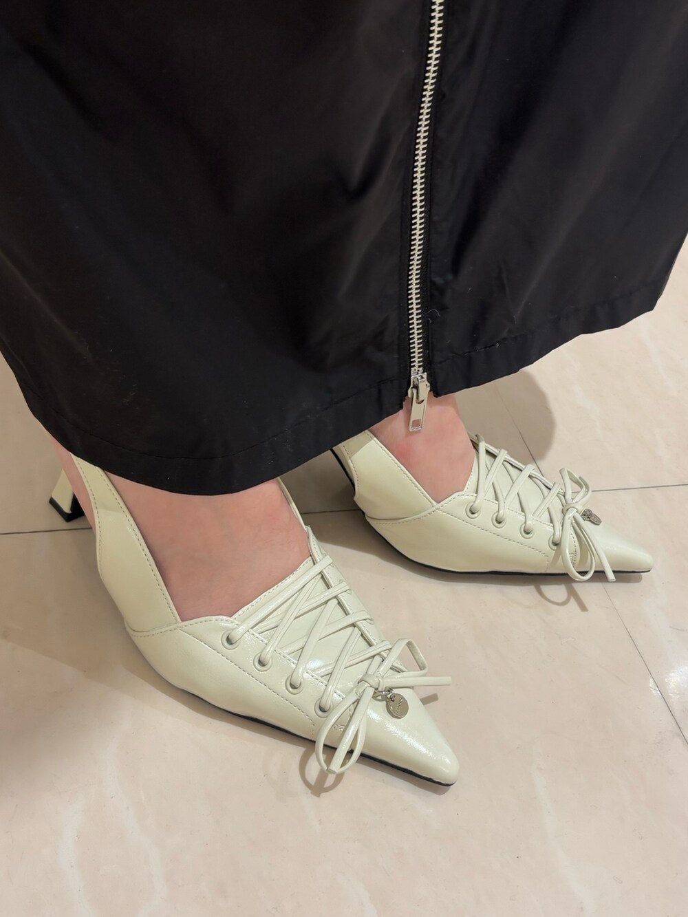 ホワイト系のパンプス、グレー系のワンピース、ブラック系のTシャツ/カットソーを着用したレディースの春コーディネートの7枚目の写真