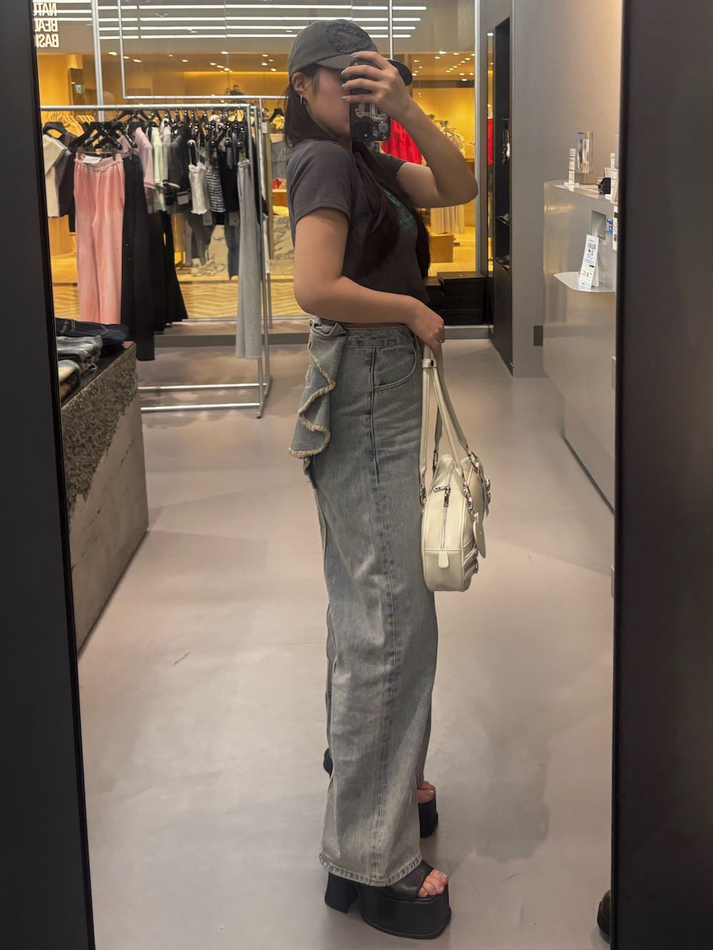 ブラック系のサンダル、ブルー系のデニムパンツ、グレー系のTシャツ/カットソーを着用したレディースの春コーディネートの2枚目の写真