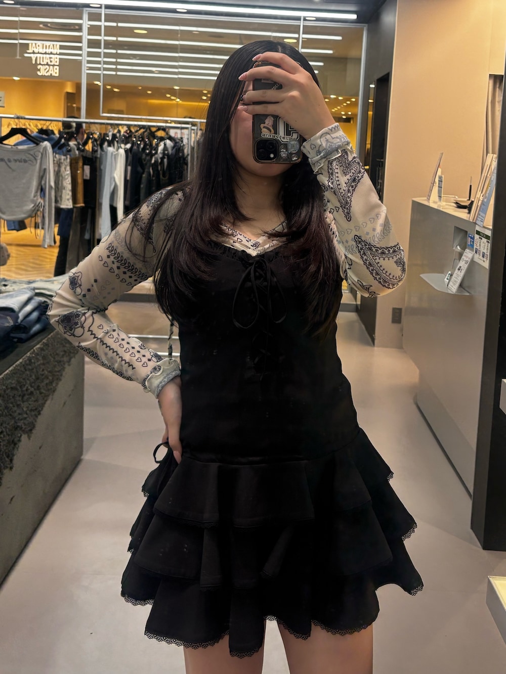 ブラック系のワンピース、ブラック系のサンダル、ホワイト系のTシャツ/カットソーを着用したレディースの春コーディネートの3枚目の写真