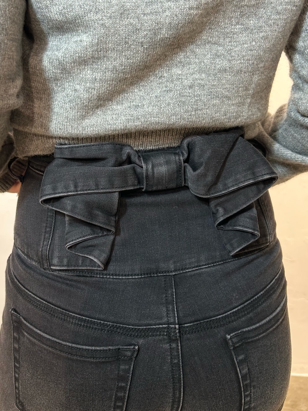 ブラック系のブーツ、ブラック系のデニムパンツ、グレー系のニット/セーターを着用したレディースの秋コーディネートの6枚目の写真