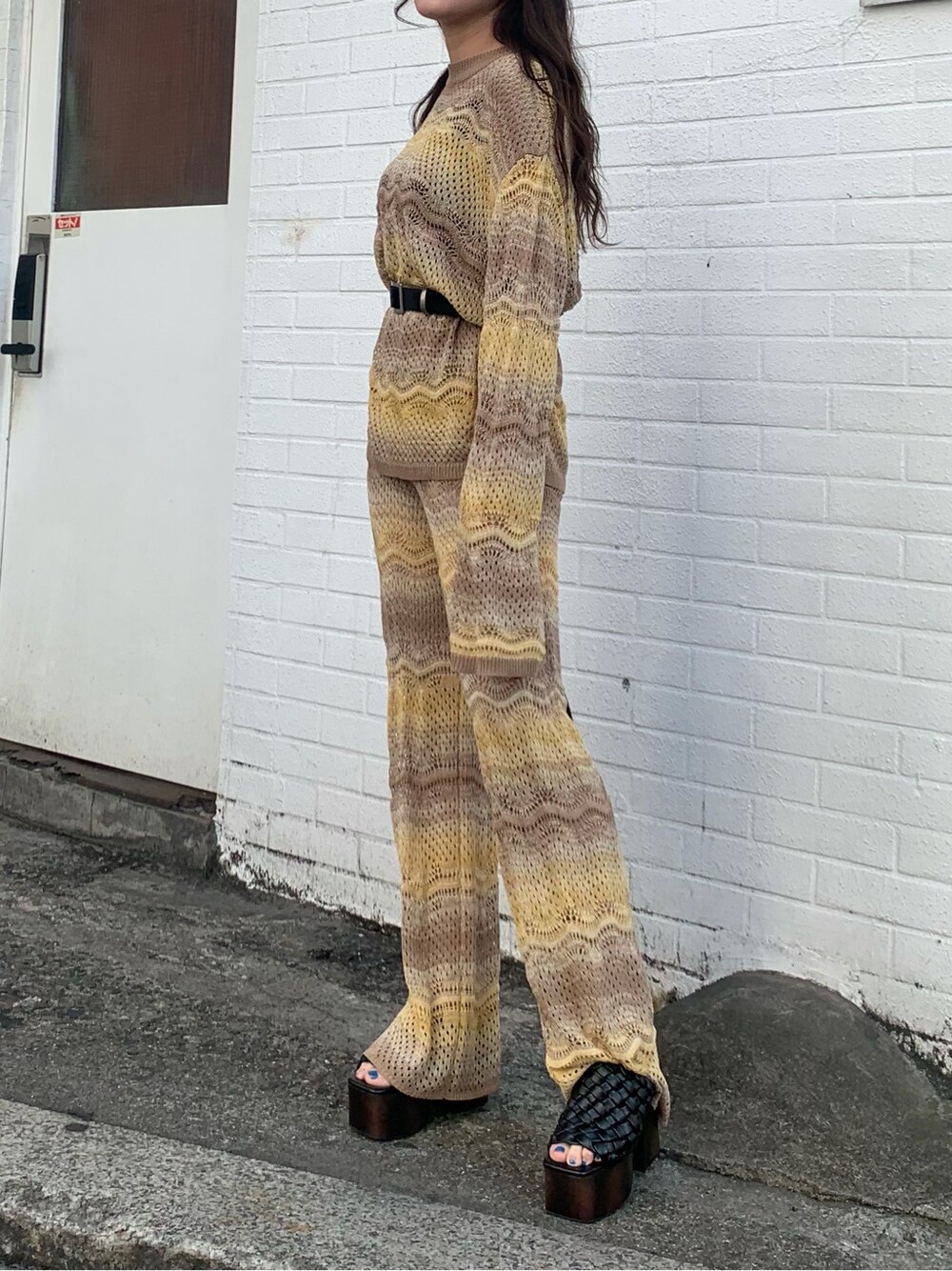 ベージュ系のその他パンツ、ブラック系のサンダル、ベージュ系のニット/セーターを着用したレディースの春コーディネートの2枚目の写真