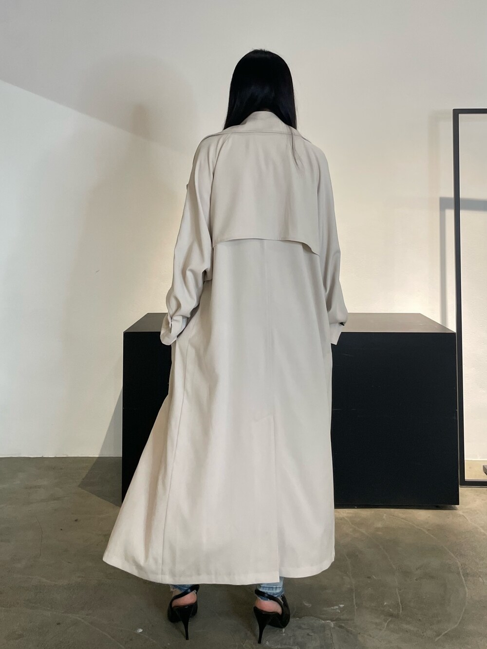 グリーン系のトレンチコート、ブラック系のパンプス、ブルー系のデニムパンツを着用したレディースの冬コーディネートの4枚目の写真