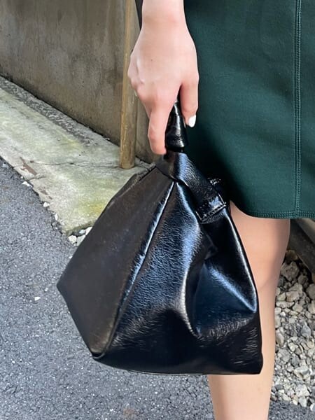 グリーン系のワンピース、ブラック系のハンドバッグを着用したレディースの夏コーディネートの4枚目の写真