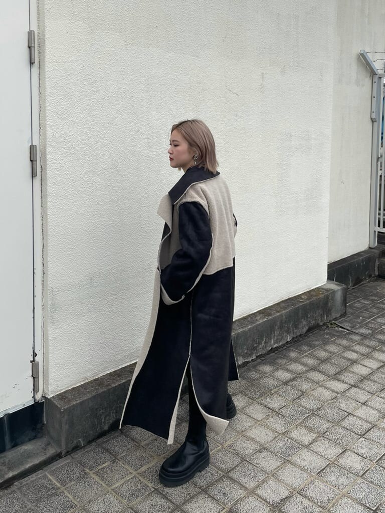 ブラック系のTシャツ/カットソー、ブラック系のデニムパンツ、ブラック系のムートンコートを着用したレディースの秋コーディネートの2枚目の写真