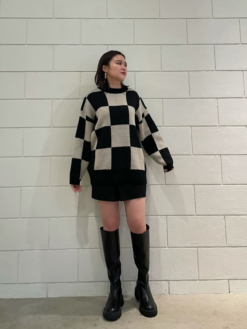 ブラック系のブーツ、ブラック系のスカート、ブラック系のニット/セーターを着用したレディースの冬コーディネートの2枚目の写真