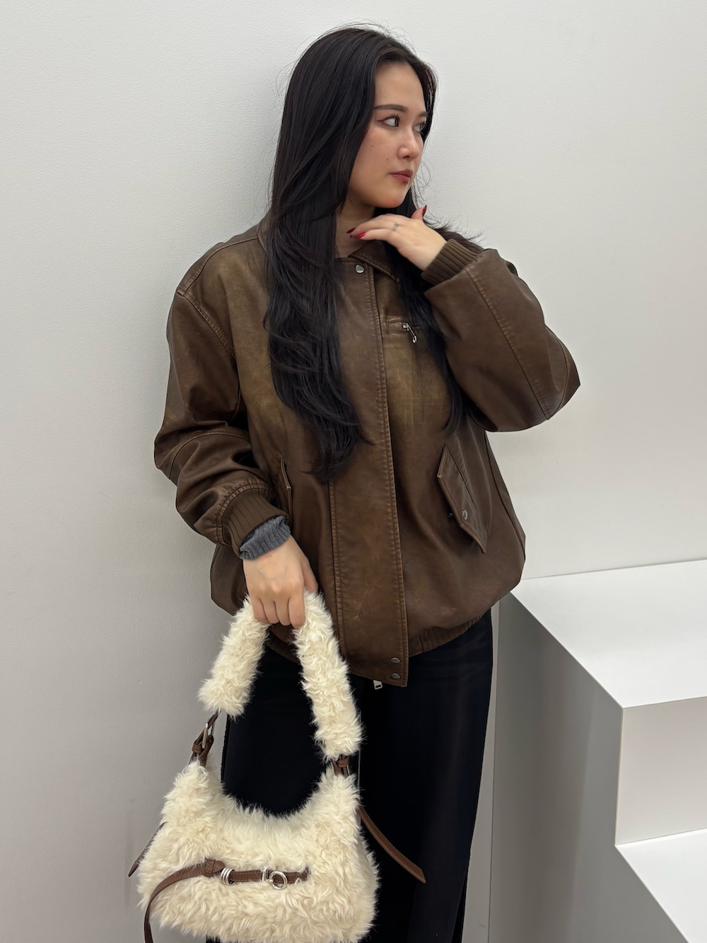 ブラック系のスウェットパンツ、ブラック系のブルゾン、ブラック系のショルダーバッグを着用したレディースの秋コーディネートの4枚目の写真