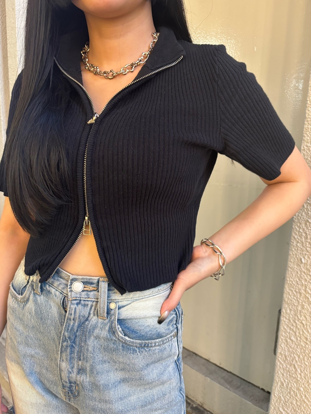 ホワイト系のデニムパンツ、ブラック系のニット/セーター、ブラック系のサンダルを着用したレディースの夏コーディネートの4枚目の写真