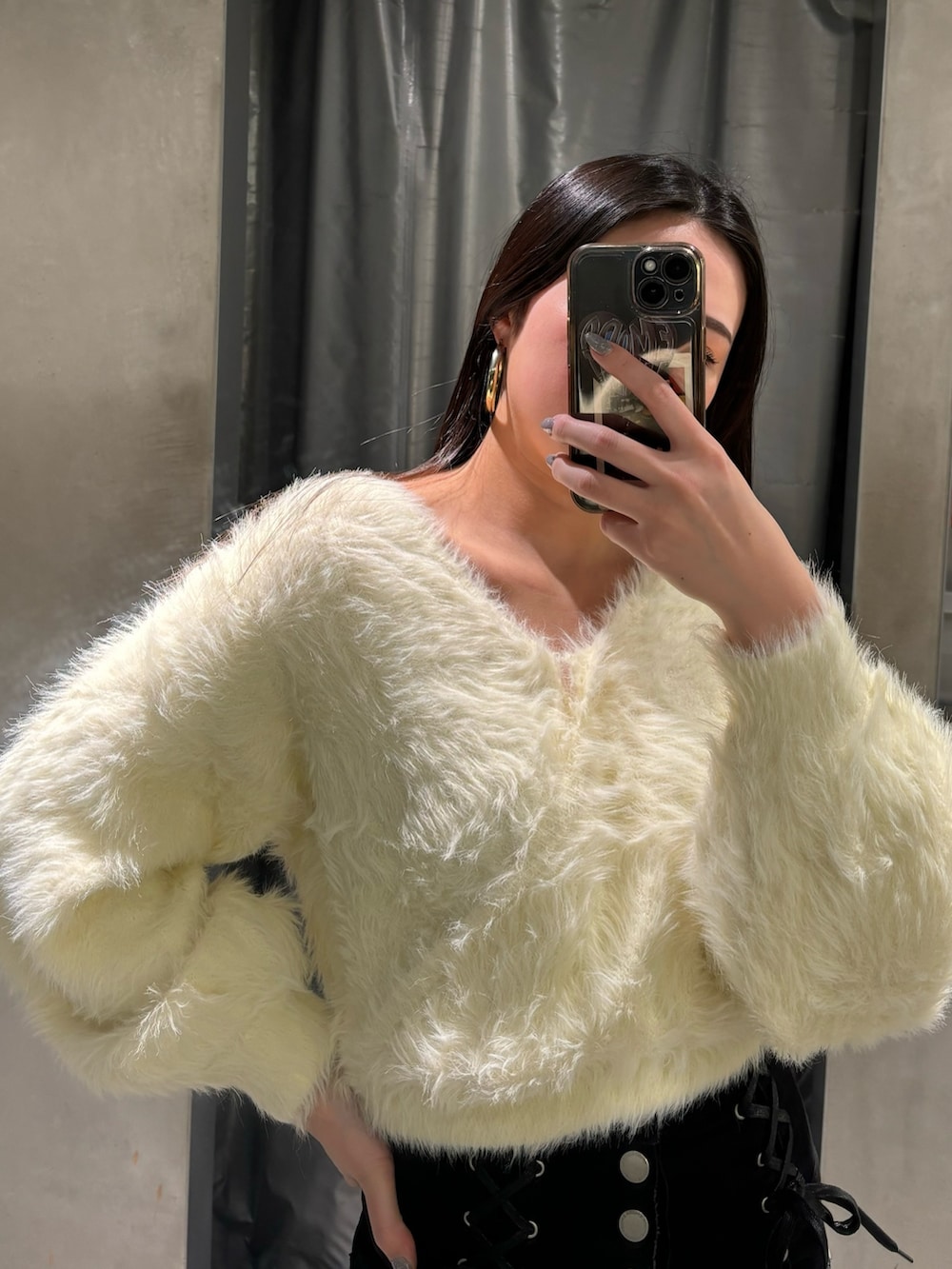 ブラック系のデニムパンツ、ホワイト系のニット/セーター、ブラック系のブーツを着用したレディースの冬コーディネートの5枚目の写真