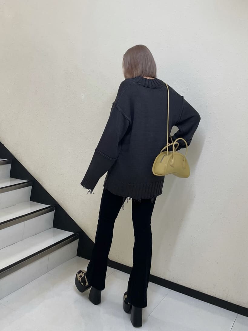 イエロー系のハンドバッグ、その他のブーツ、グレー系のニット/セーターを着用したレディースの秋コーディネートの3枚目の写真