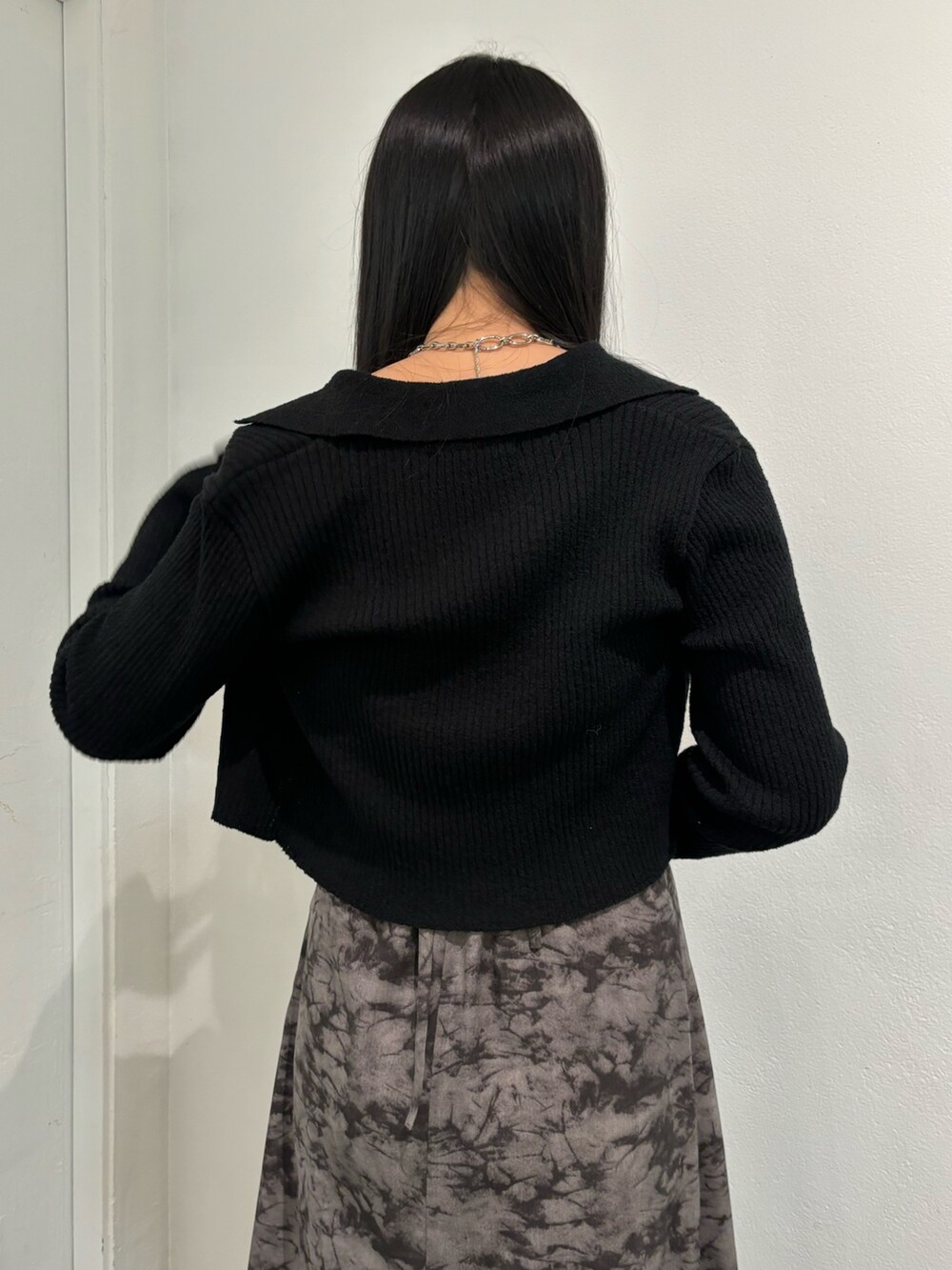 ブラック系のニット/セーター、ブラック系のショルダーバッグを着用したレディースの春コーディネートの7枚目の写真