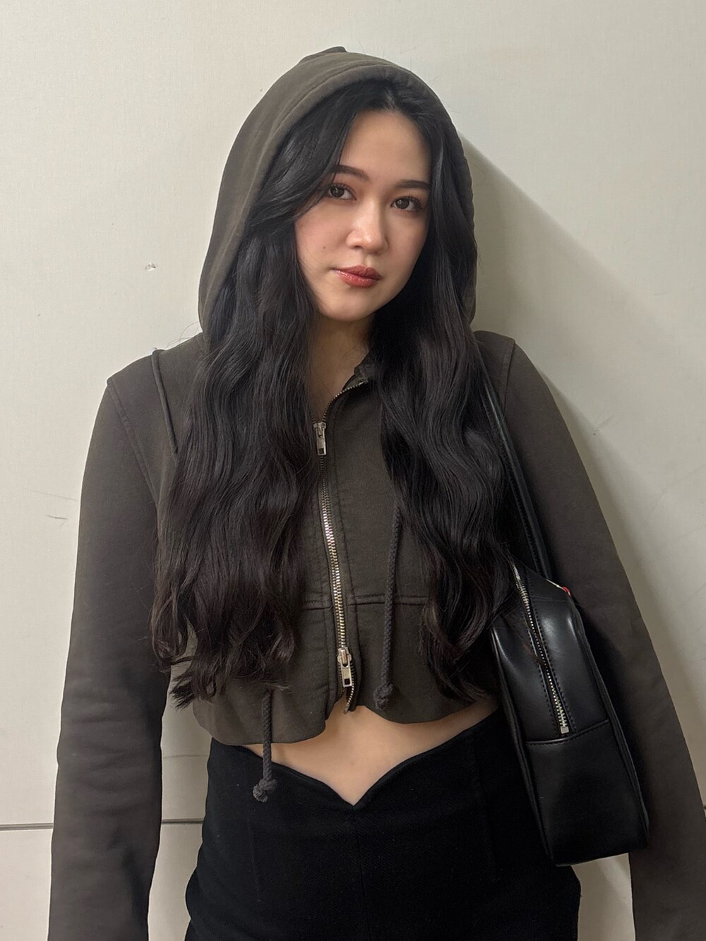 ブラック系のスカート、ブラック系のブーツ、ブラック系のハンドバッグを着用したレディースの春コーディネートの3枚目の写真